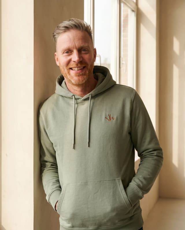 De Organic Cotton Hoodie in olijfgroen, gedragen.